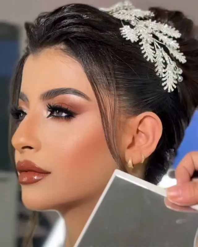 عروس بتسريحة مرفوعة وتاج فضي